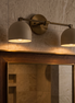 Caldera brushed brass dome vanity wall light above a mirror